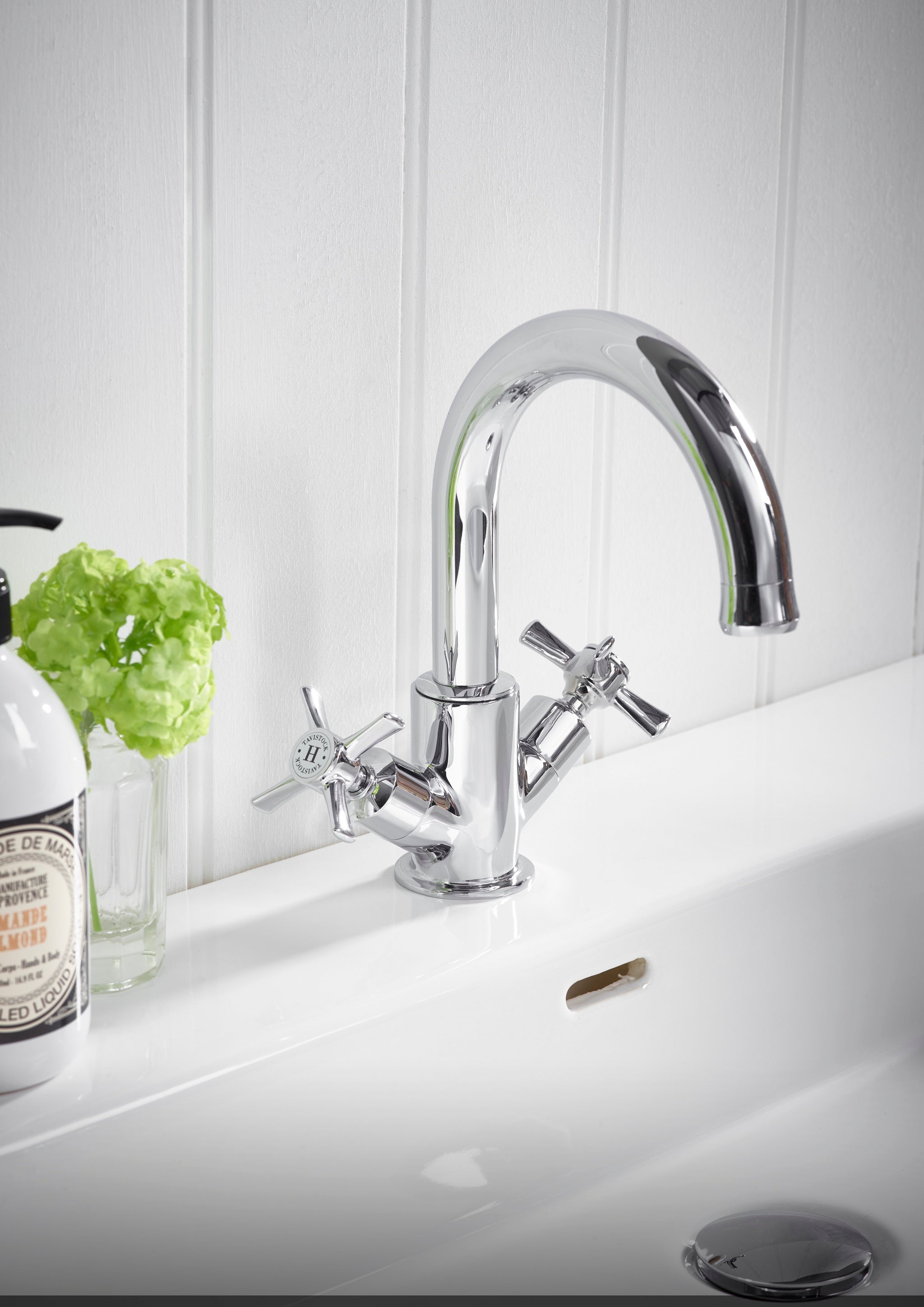 Tavistock Cheltenham Basin Mixer With Click Waste - Chrome close up view of basin against white wooden wall TCM11