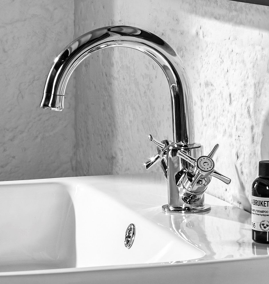 Tavistock Cheltenham Basin Mixer With Click Waste - Chrome close up view of the basin against white rock wall TCM11