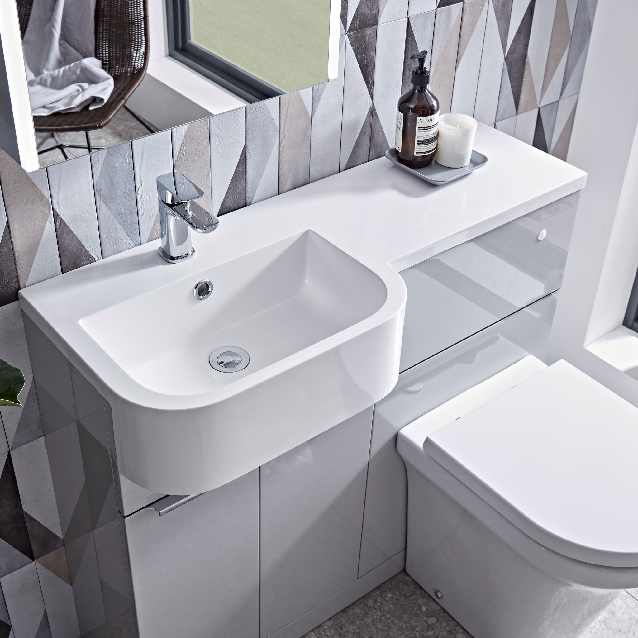 Tavistock Match 1000mm Combination Unit - Gloss Light Grey (L or R Hand) unit against wooden wallpaper design underneath a mirror MATLG