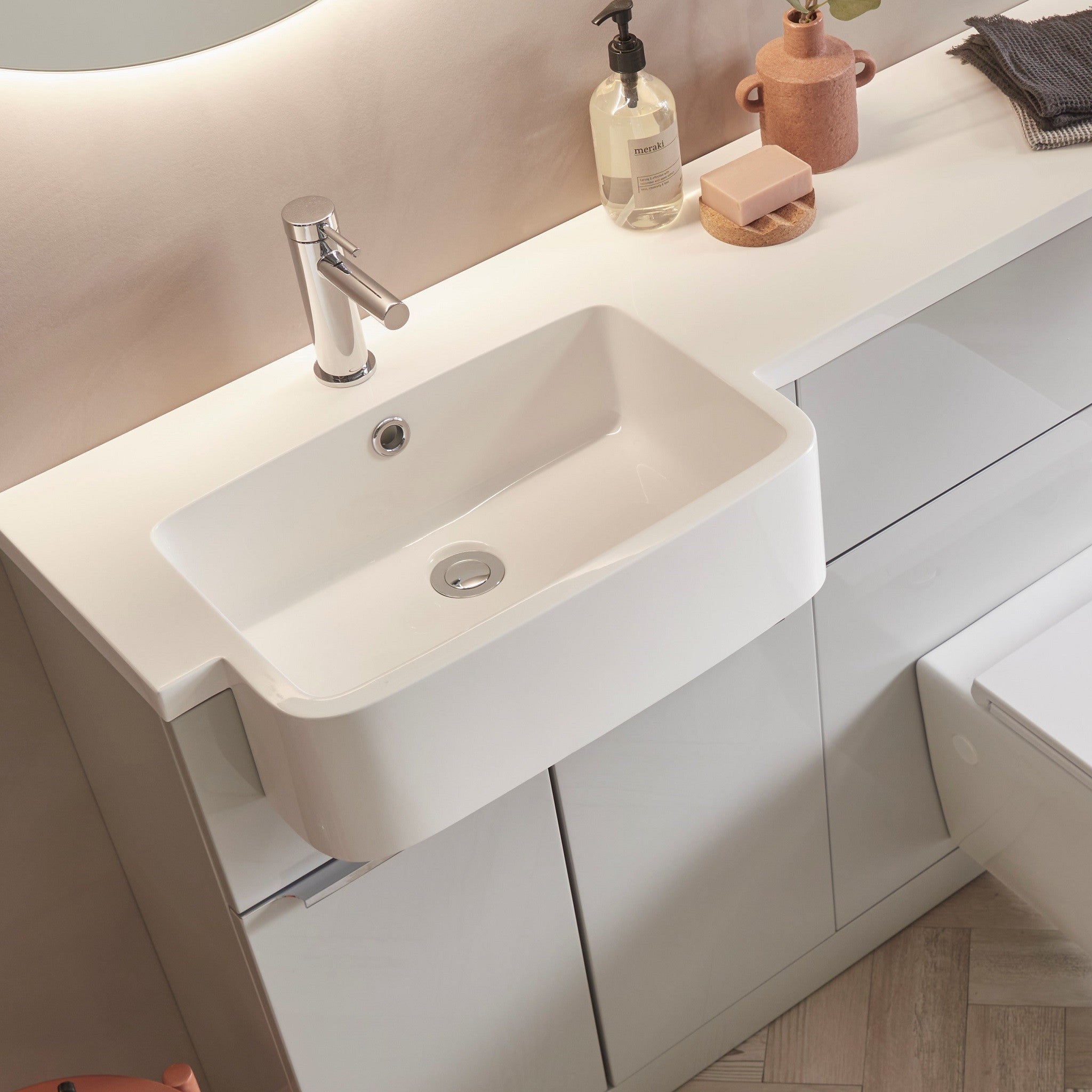 Tavistock Match 1200mm Combination Unit - Gloss Light Grey (L or R Hand) close up view against pal painted wall underneath a light up mirror MAT12LG