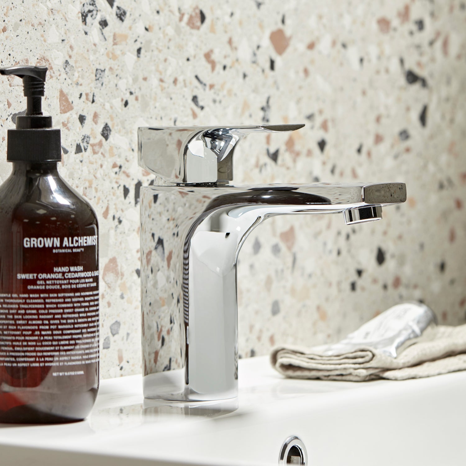 Tavistock Siren Basin Mixer With Click Waste - Chrome close up view against a mix colour stone wall TSN11