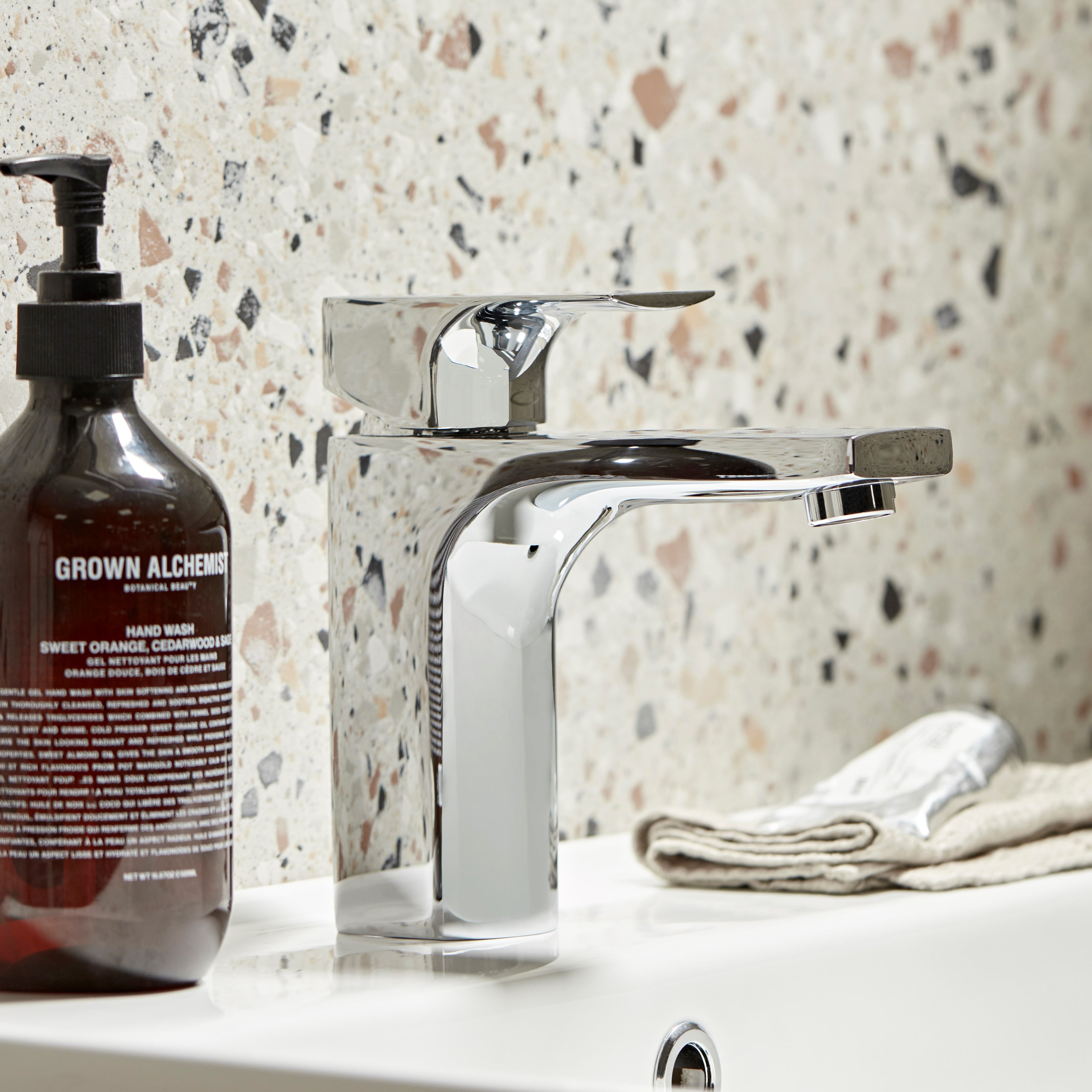 Tavistock Siren Basin Mixer With Click Waste - Chrome close up view against a mix colour stone wall TSN11