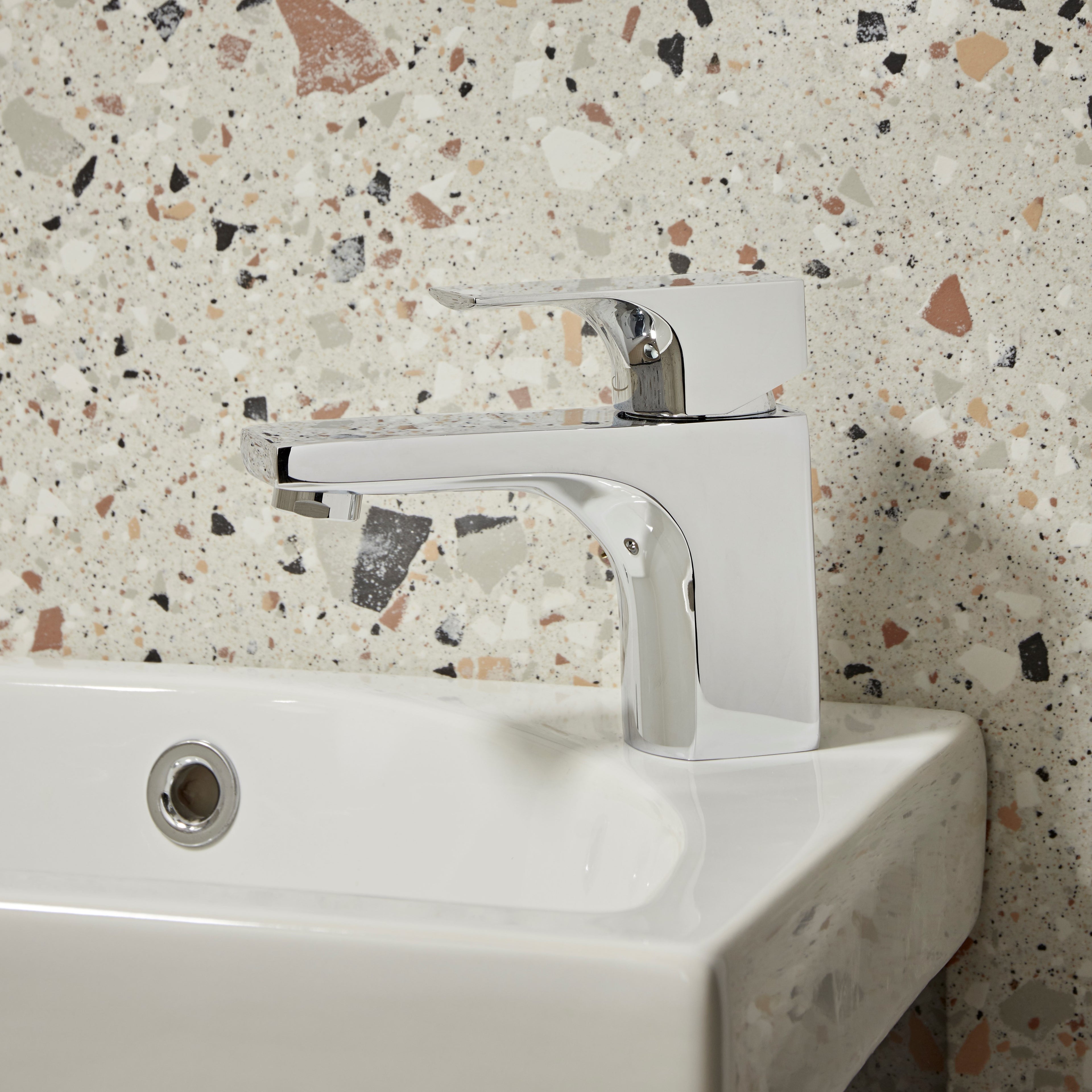 Tavistock Siren Basin Mixer With Click Waste - Chrome close up view against a mix colour stone wall TSN11