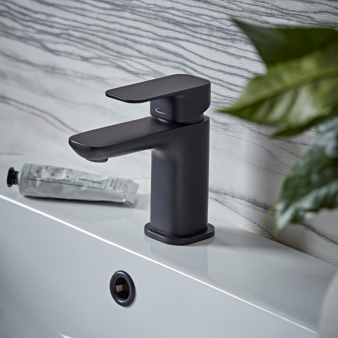 Tavistock Haze Mini Basin Mixer With Click Waste against wooden wallpaper design THZ6103