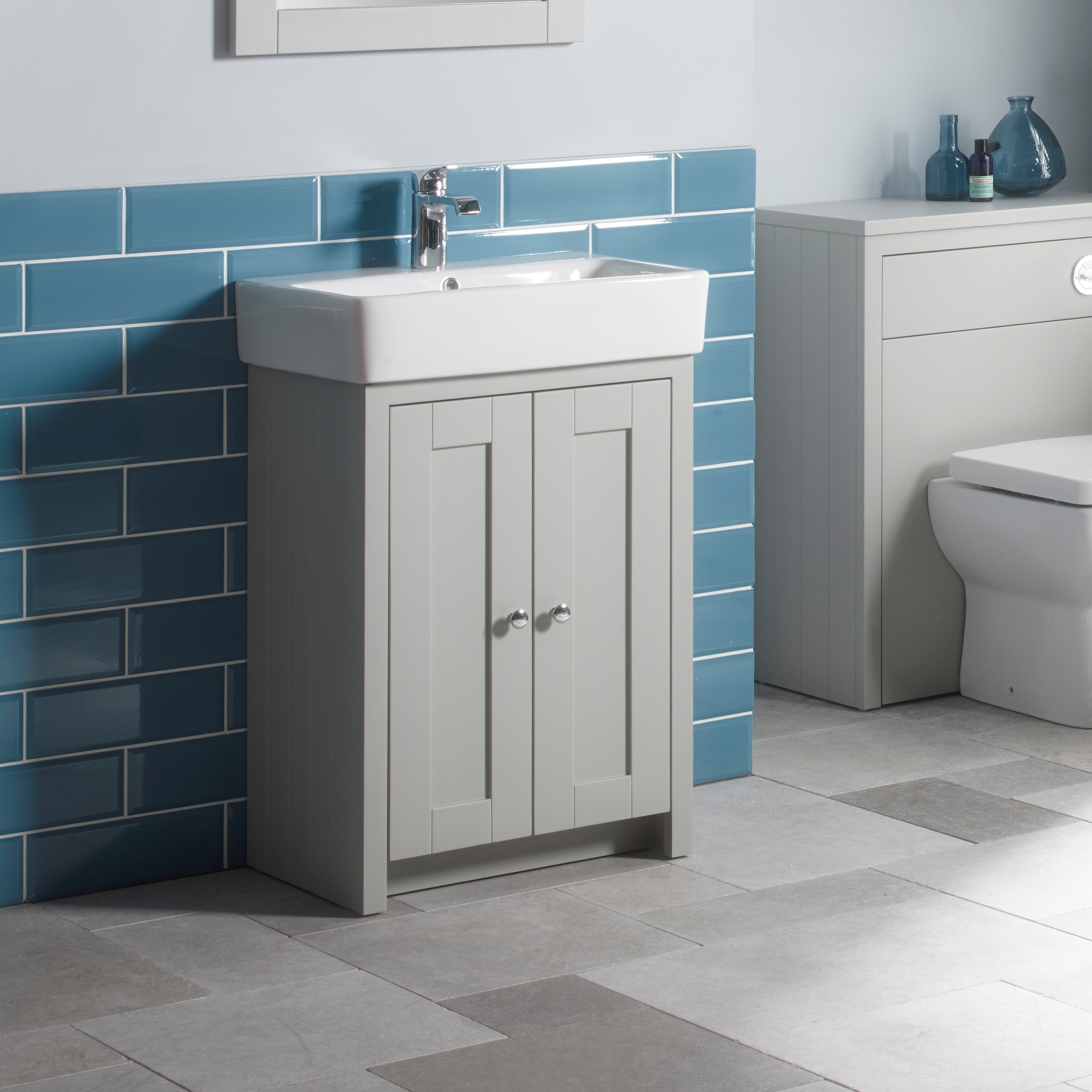 Tavistock Lansdown 575mm Freestanding Unit & Basin - Various Colours against light blue tiling underneath a white mirror LAN550B.PG