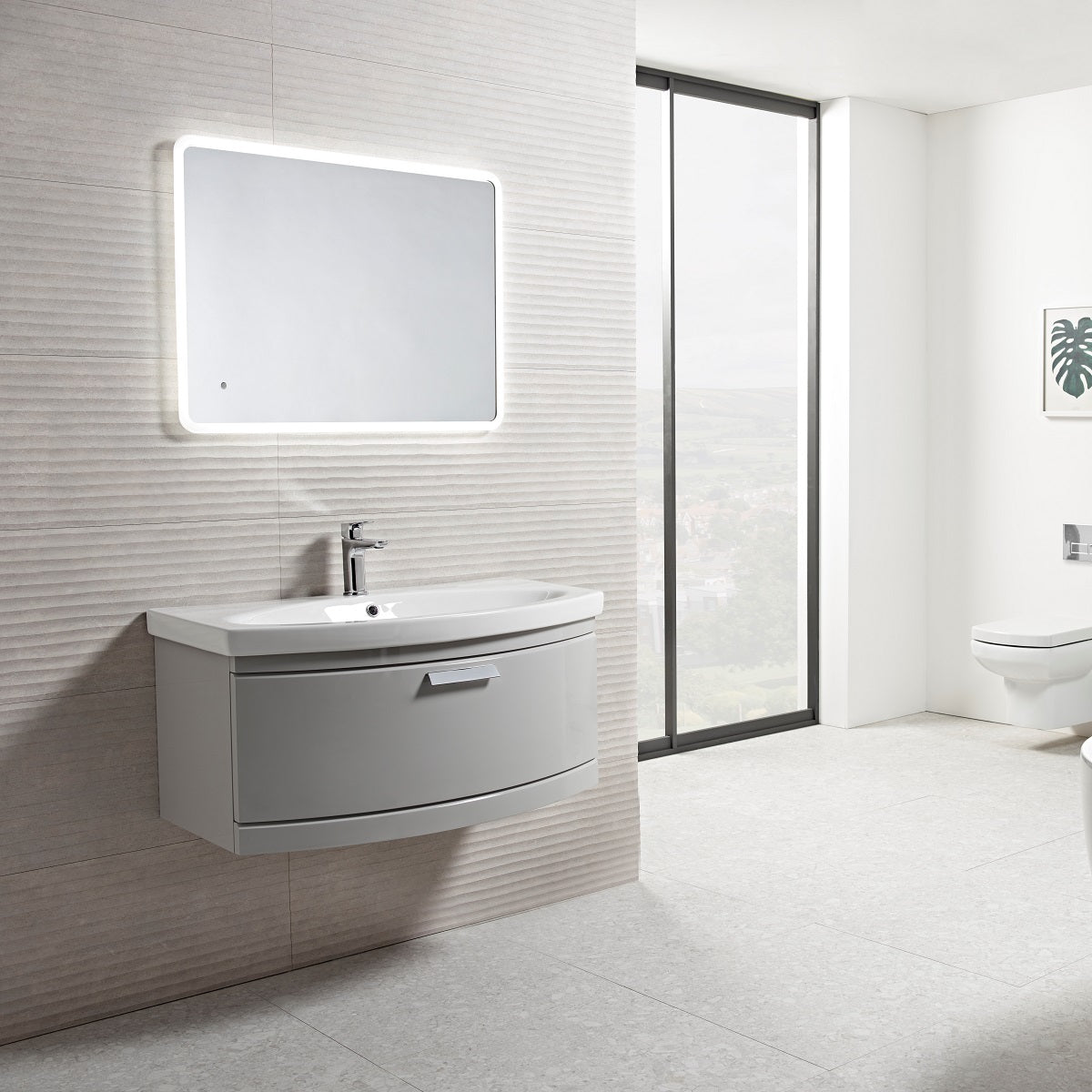 Tavistock Tempo 900mm Wall Mounted Unit & Basin - Various Colours wide view showing the unit against a stone wall design underneath a light up mirror TE900WG