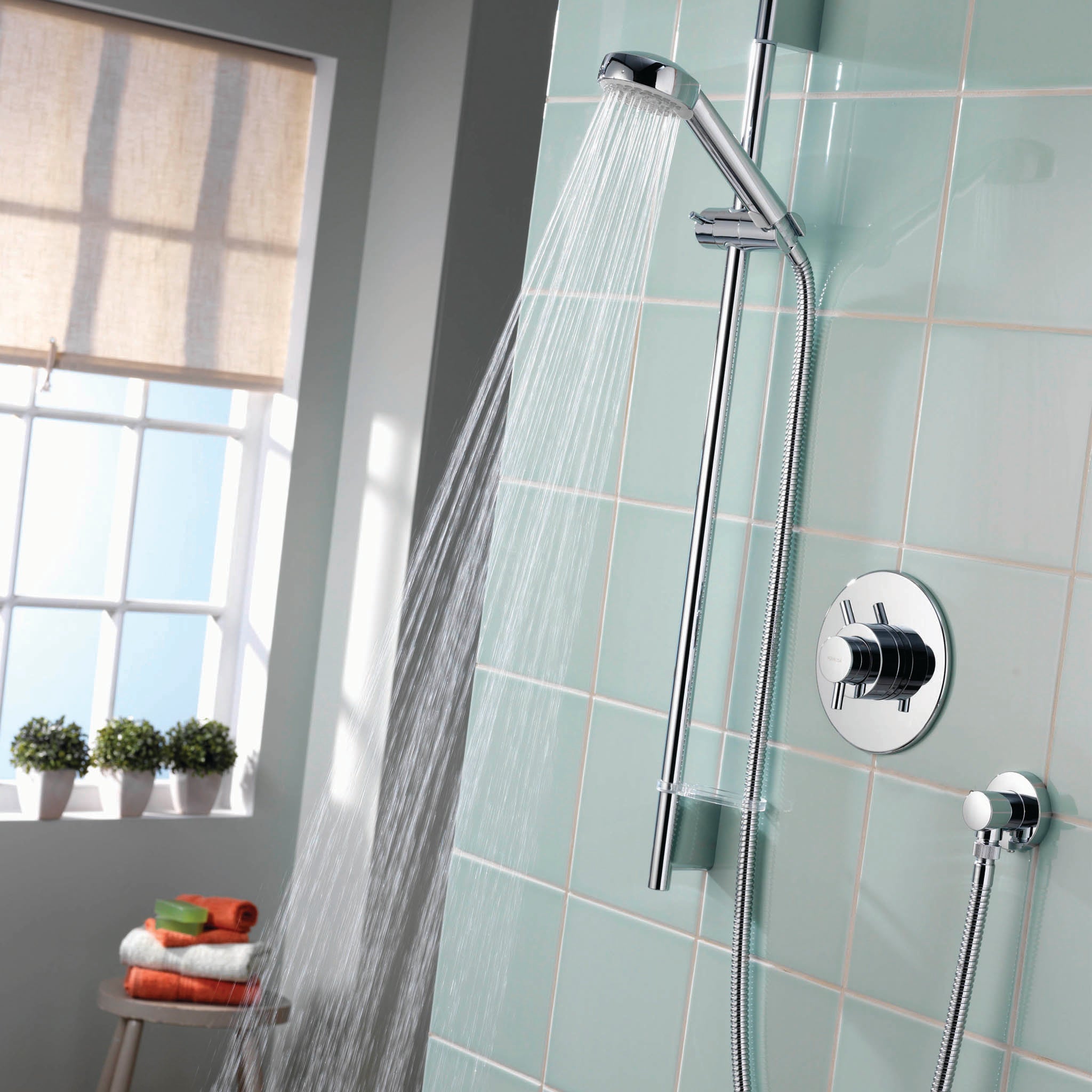 Aqualisa Aspire Mixer Shower with green wall tiles with water flowing ASP001CA