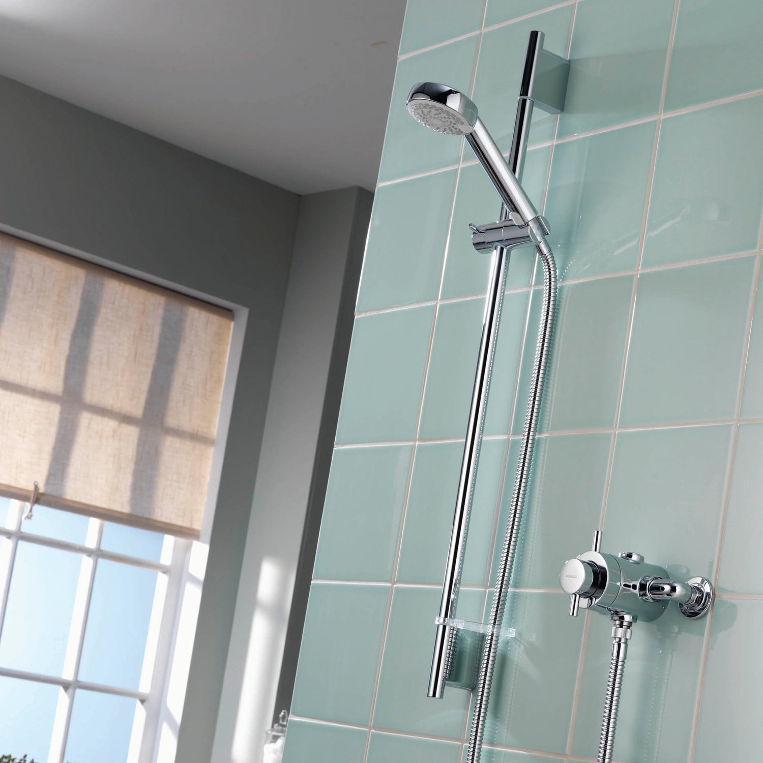 Aqualisa Aspire Mixer Shower with green wall tiles with water flowing ASP001EA