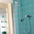 Aqualisa Siren Shower - Exposed With Adjustable Head against light blue wall water flowing SRN001EA