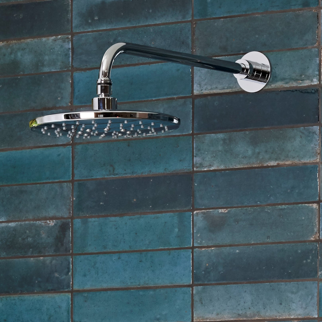Tavistock Axiom Dual Function Push Button Shower System With Head And Outlet up close shower head against blue tiling SAX2549