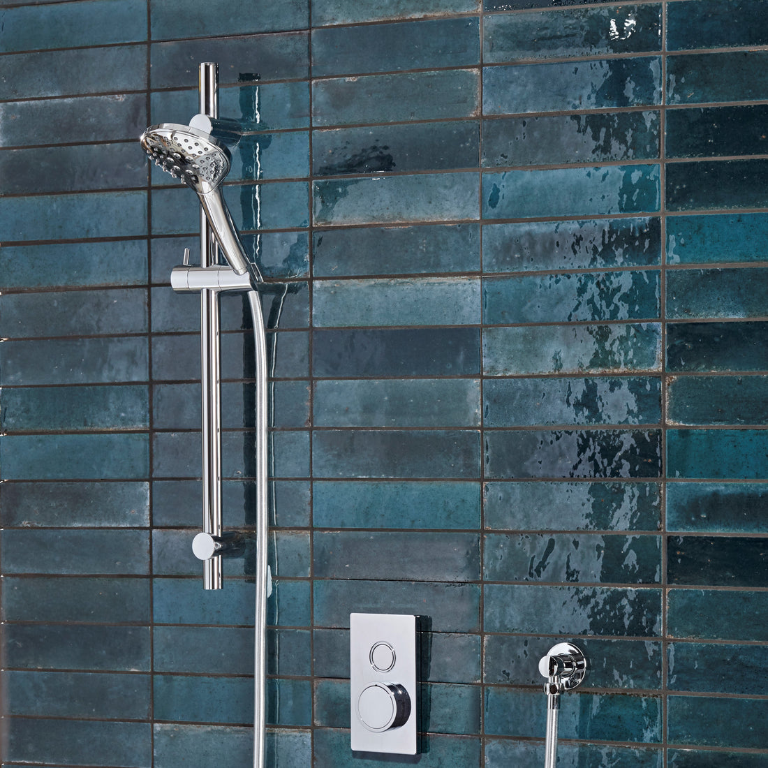 Tavistock Axiom Single Function Push Button Shower System With Riser Kit - Chrome against blue tiling SAX2316