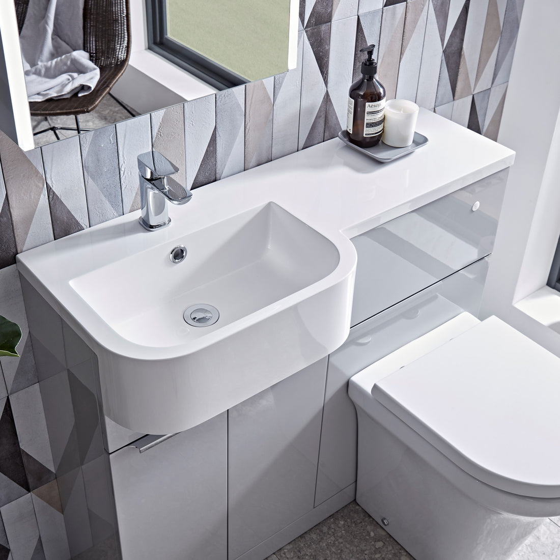 Tavistock Match 1000mm Combination Unit - Gloss Light Grey (L or R Hand) unit against wooden wallpaper design underneath a mirror MATLG