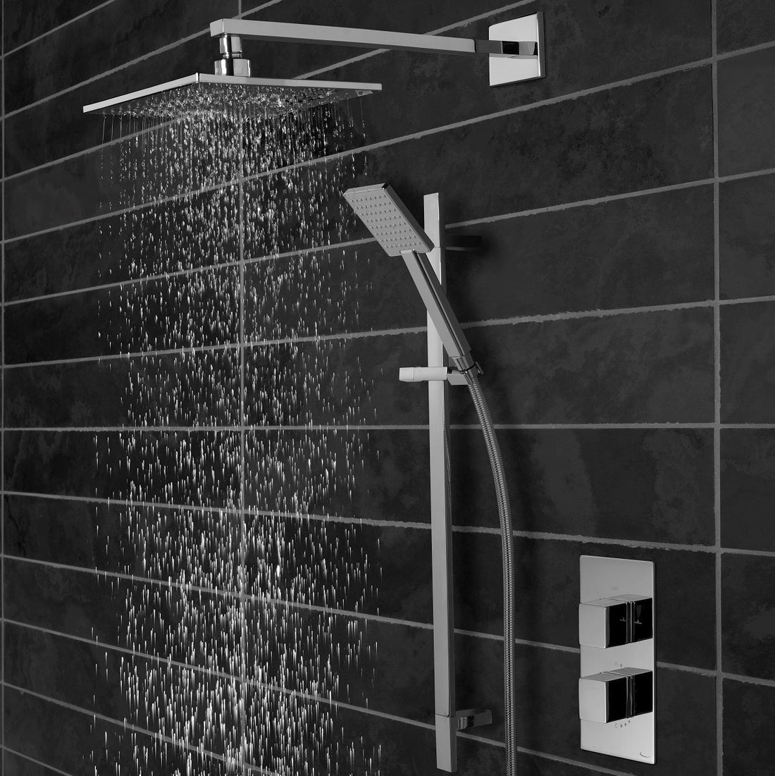 Tavistock Index Concealed Thermostatic Two Outlet Shower with Fixed Head against dark grey tiling with shower head poring water SND1610