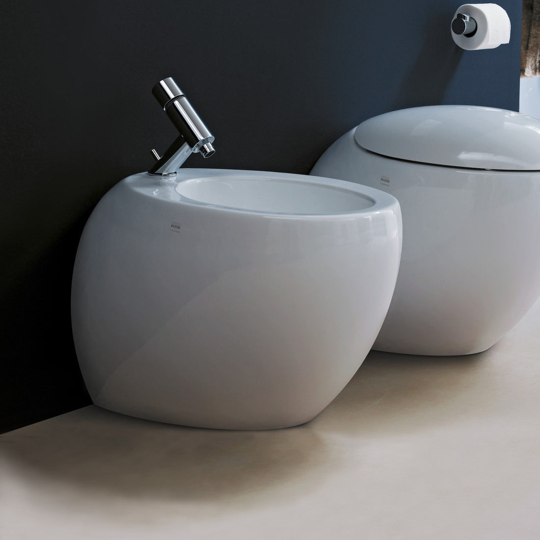 Laufen Ilbagnoalessi One white floorstanding Bidet next to matching back-to-wall pan against dark grey painted wall. 