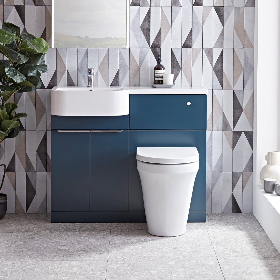 Tavistock Match 1000mm Oxford BlueTavistock Match 1000mm Combination Unit - Oxford Blue (L or R Hand) against a wooden wallpaper design underneath a mirror MATLOB